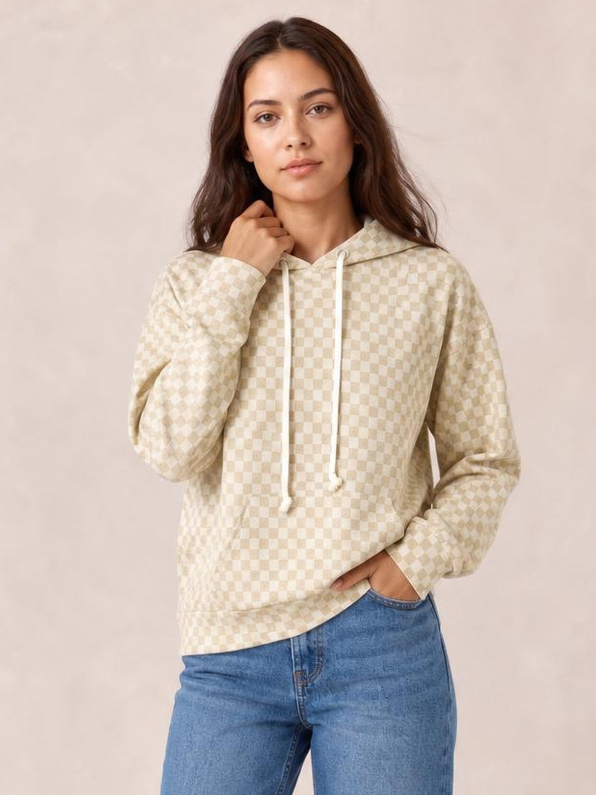 Model wears an oversized cream checkered print hoodie with a kangaroo pocket, drawstring hood, long sleeves, and relaxed silhouette.