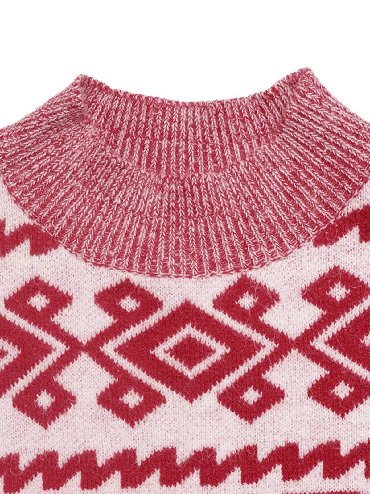 Close-up of a red and white Christmas sweater showing its ribbed round neckline, textured knit construction, and repeating geometric pattern.