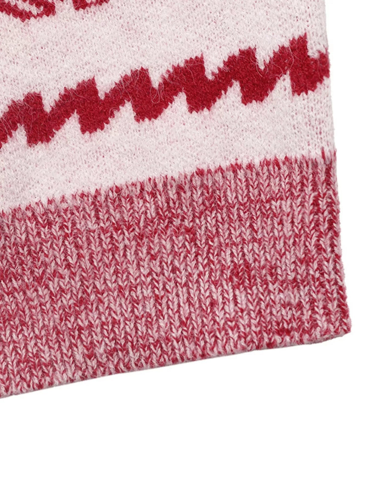 Close-up of the Christmas sweater’s red-and-white knit construction, featuring a bold zigzag band and textured ribbed hem.