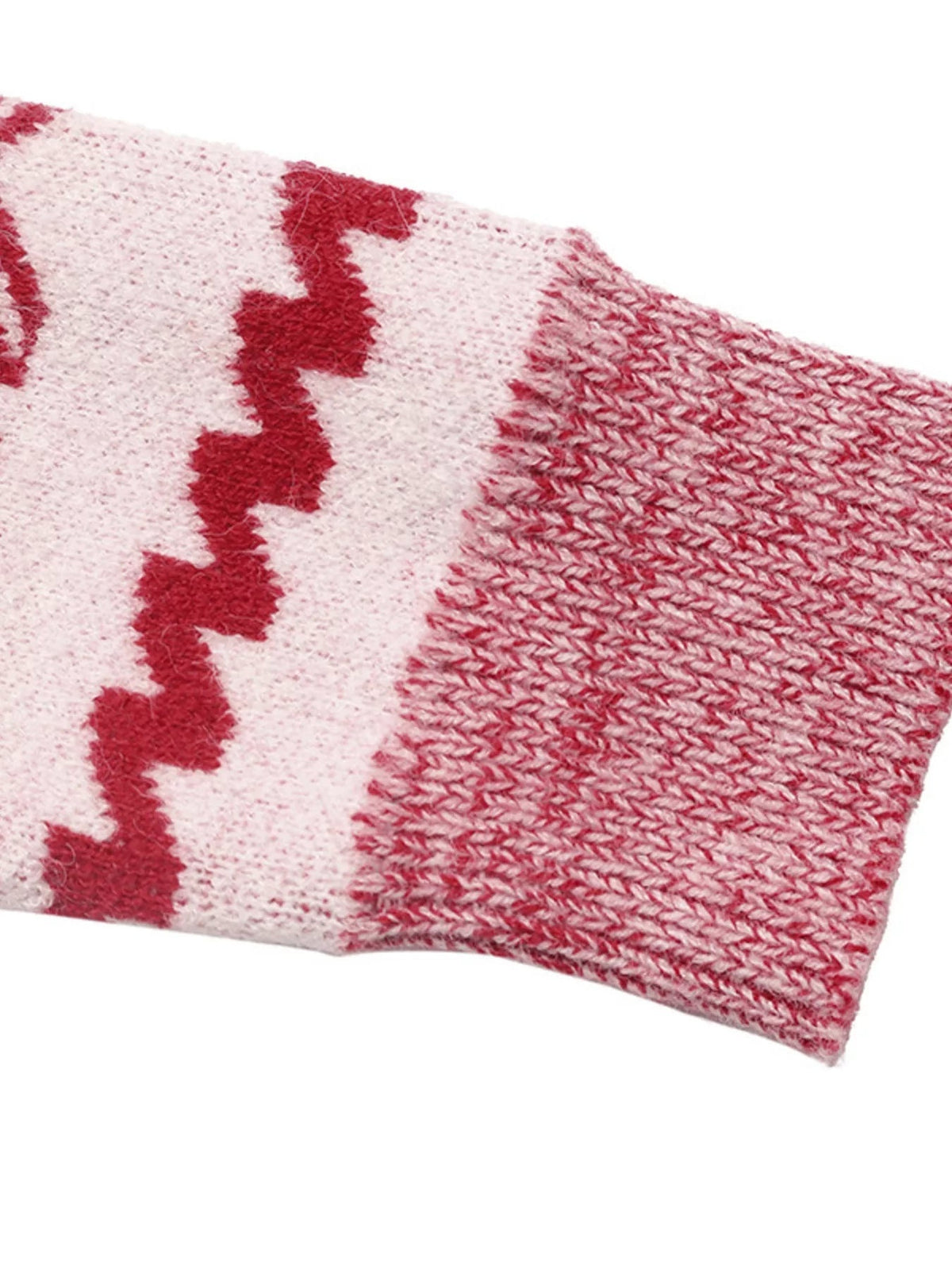 Close-up of the pink and red knit long sleeve on a Christmas sweater, showing textured stitching and a repeating red holiday motif.