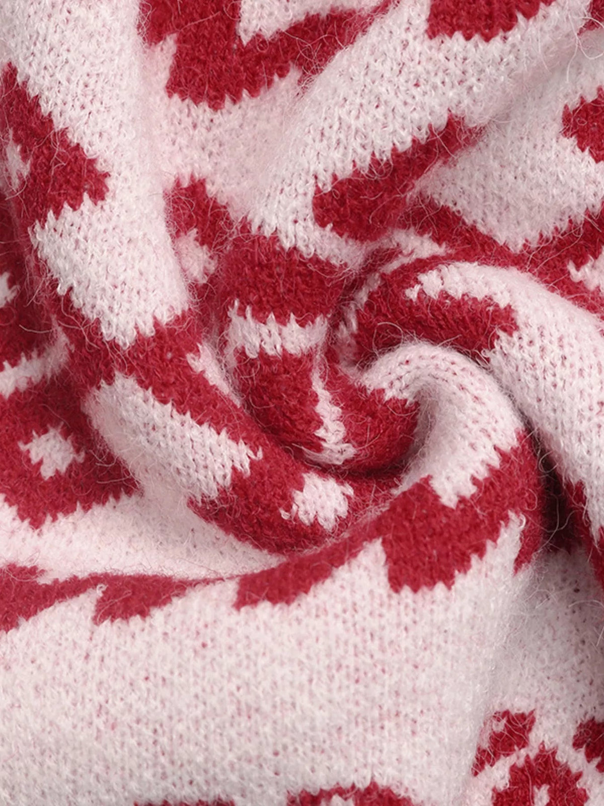 Close-up of the fuzzy red and pale pink knit fabric with a soft textured construction from the Christmas round neck long sleeve sweater.