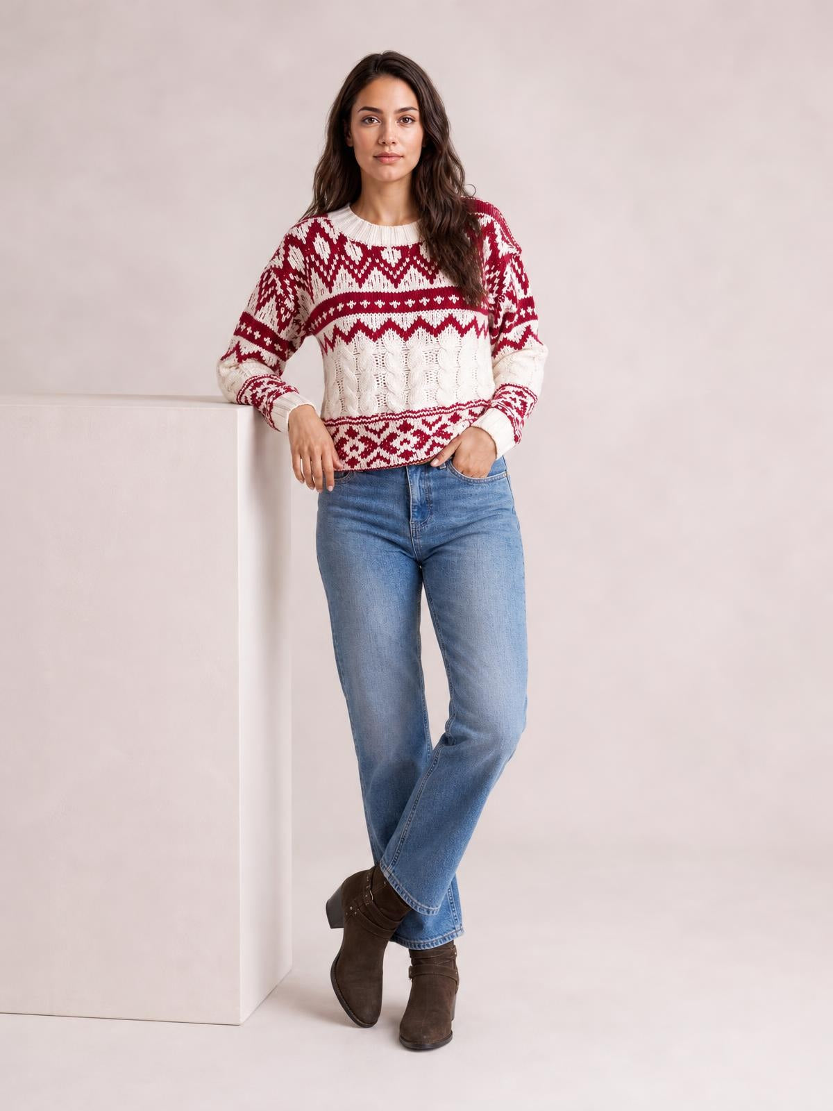 Model poses in a red and white Christmas cable knit sweater with long sleeves, ribbed crew neck and cuffs, and a relaxed silhouette.