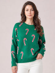 Model wearing a green ribbed drop-shoulder Christmas sweater with red-and-white candy cane motifs, crew neck, relaxed silhouette, and ribbed cuffs and hem.