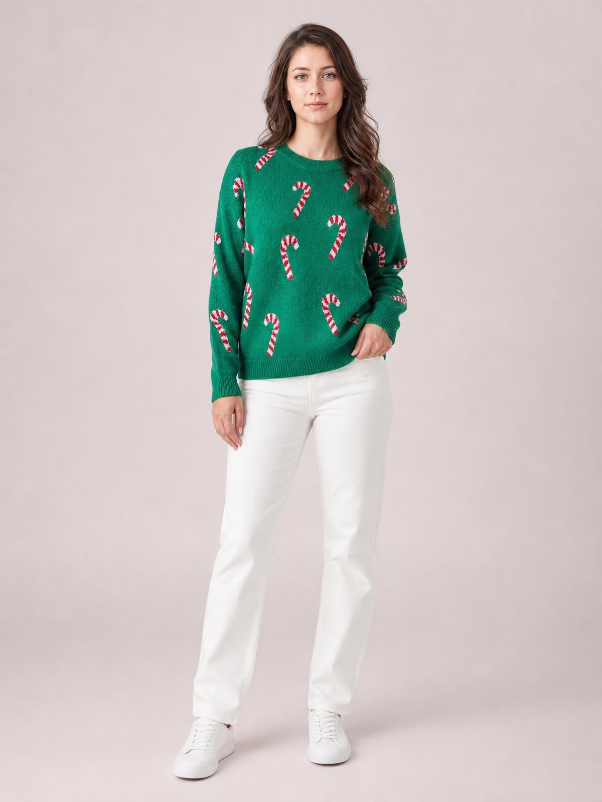 A woman stands in a relaxed green holiday sweater with a drop-shoulder silhouette, ribbed crew neckline, cuffs and hem, and red-and-white candy cane motifs.