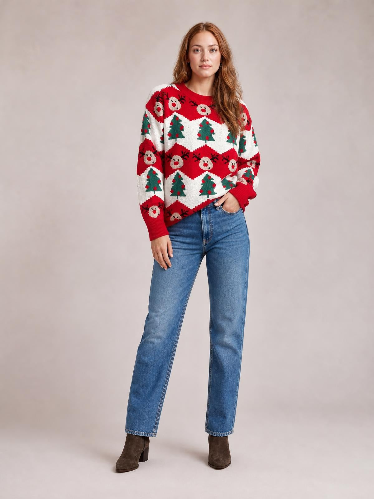 Model wearing a red, white, and green Christmas sweater with a round neck, long sleeves, relaxed silhouette, and festive reindeer and tree pattern.
