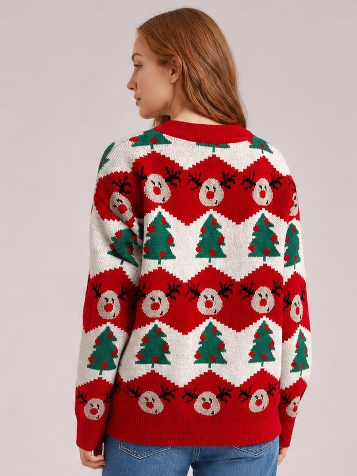 Model shown from the back wearing a festive Christmas sweater with a round neck, long sleeves, red ribbed trims, and reindeer and Christmas tree patterns.
