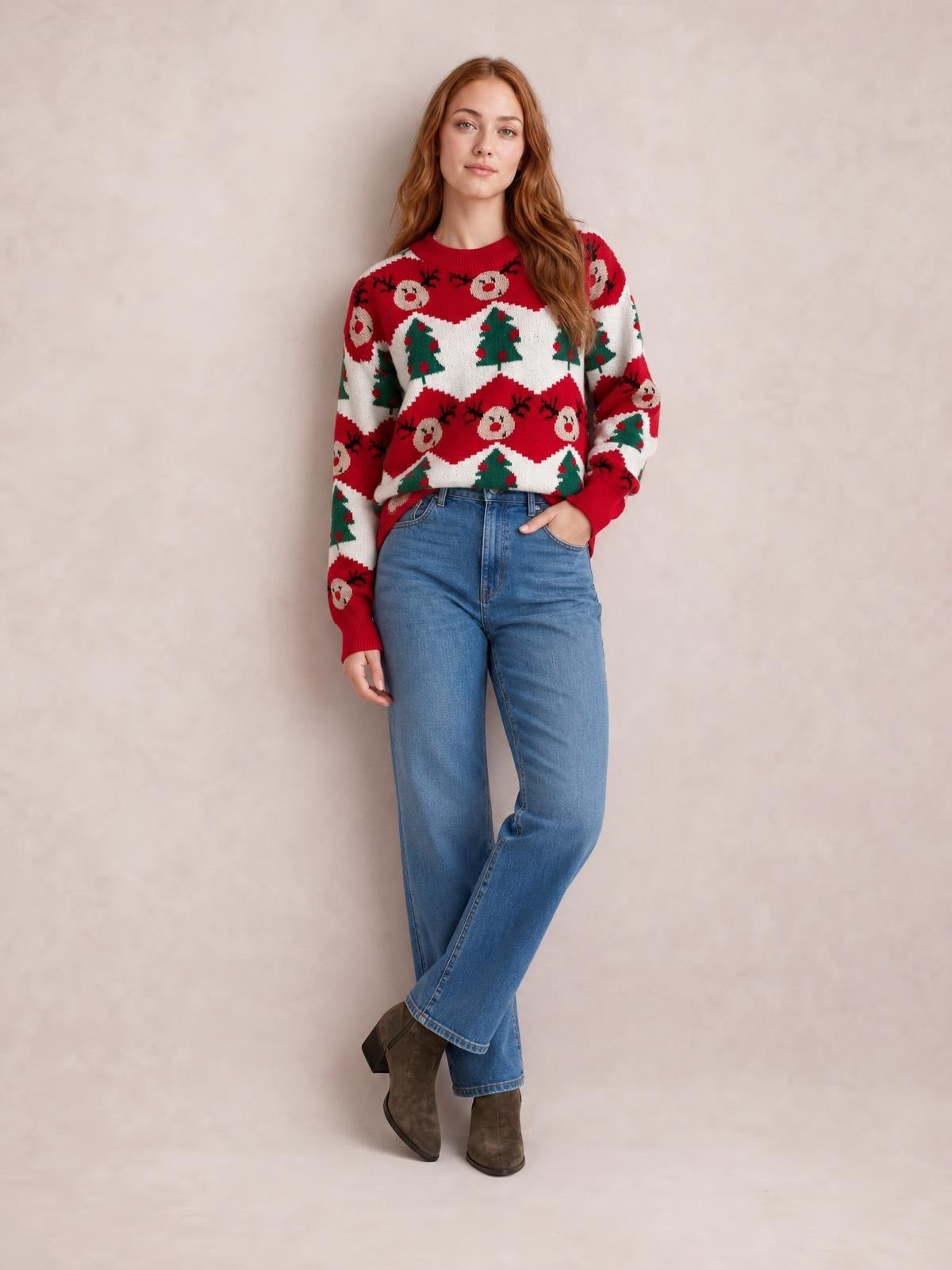 A model wears a red Christmas sweater with a round neck, long sleeves, and festive reindeer and tree patterns in a relaxed silhouette.