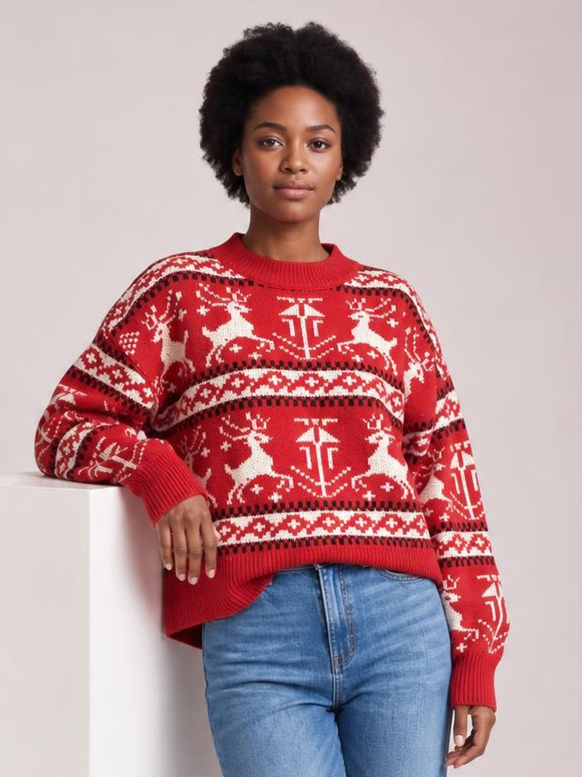 Model wearing a red Christmas element sweater with a round neck, long sleeves, festive white reindeer and snowflake patterns, ribbed trims, and a relaxed silhouette.