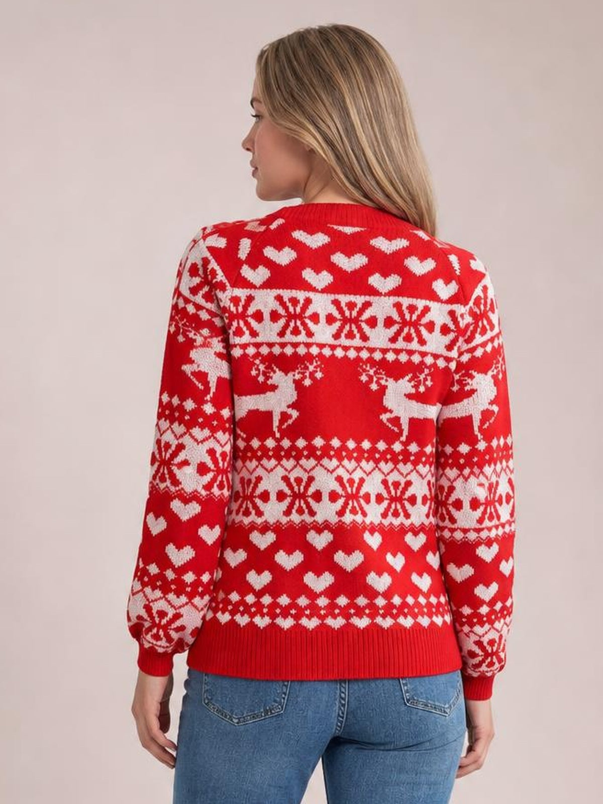 Model shown from behind wears a red Christmas sweater with a round neck, long sleeves, white hearts, snowflakes and reindeer, plus ribbed cuffs and hem.