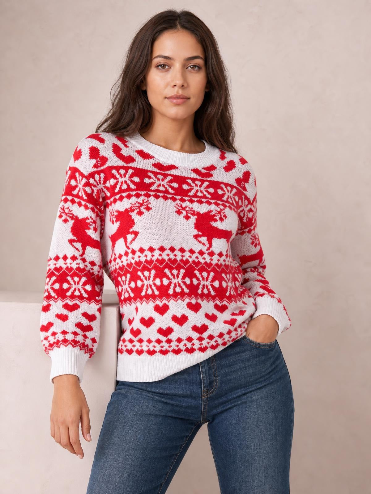 Model wears a red and white Christmas sweater with a round neck, long sleeves, reindeer, snowflake and heart motifs, ribbed cuffs and hem, and a relaxed fit.