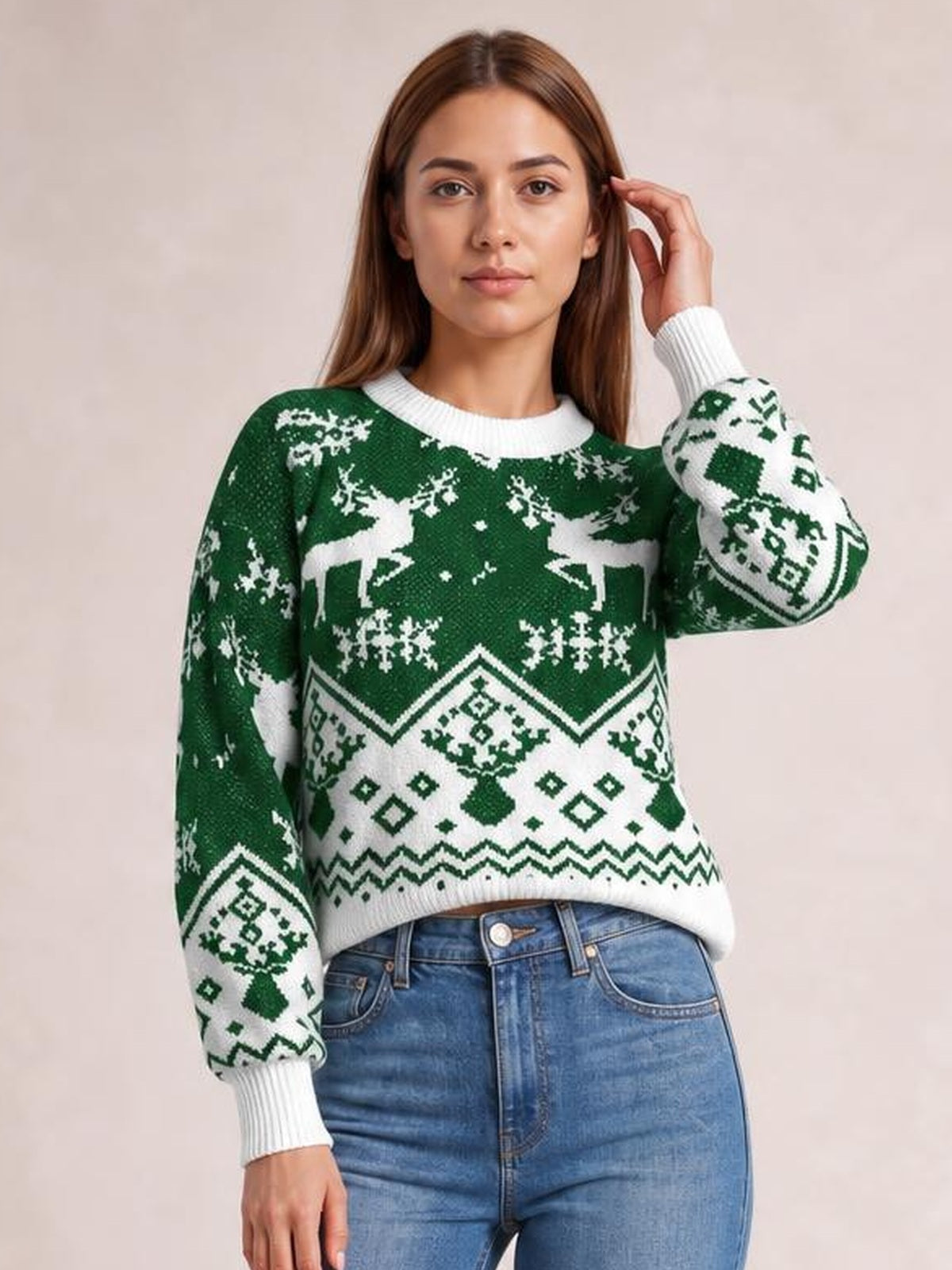 Model poses in a green and white Christmas sweater with a round neck, long sleeves, ribbed cuffs and hem, and festive reindeer and snowflake patterns.