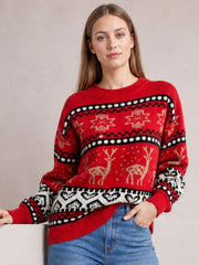 Model poses in a red Christmas sweater with a round neck, long sleeves, relaxed silhouette, ribbed trims, and festive reindeer and snowflake patterns.