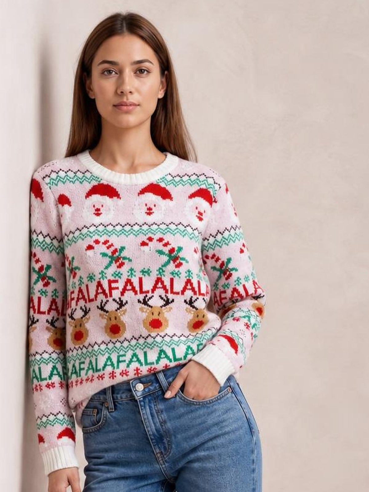 Model wearing a pale pink Christmas sweater with a round neck, long sleeves, ribbed cuffs, and colorful Santa, reindeer, holly, and snowflake motifs.