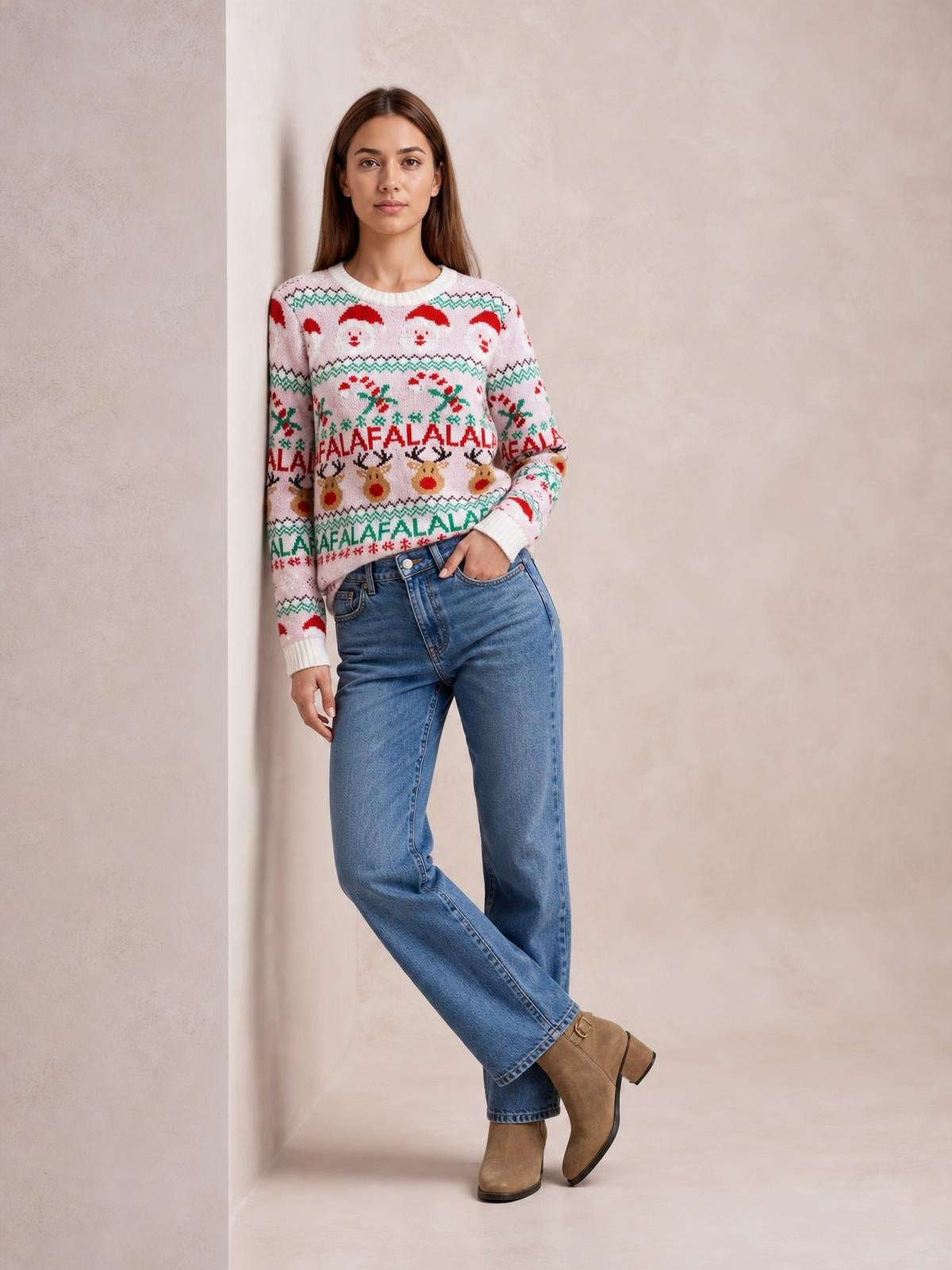 A woman models a festive Christmas sweater with a round neck, long sleeves, ribbed trims, and colorful Santa, reindeer, and holiday lettering in a relaxed pose.