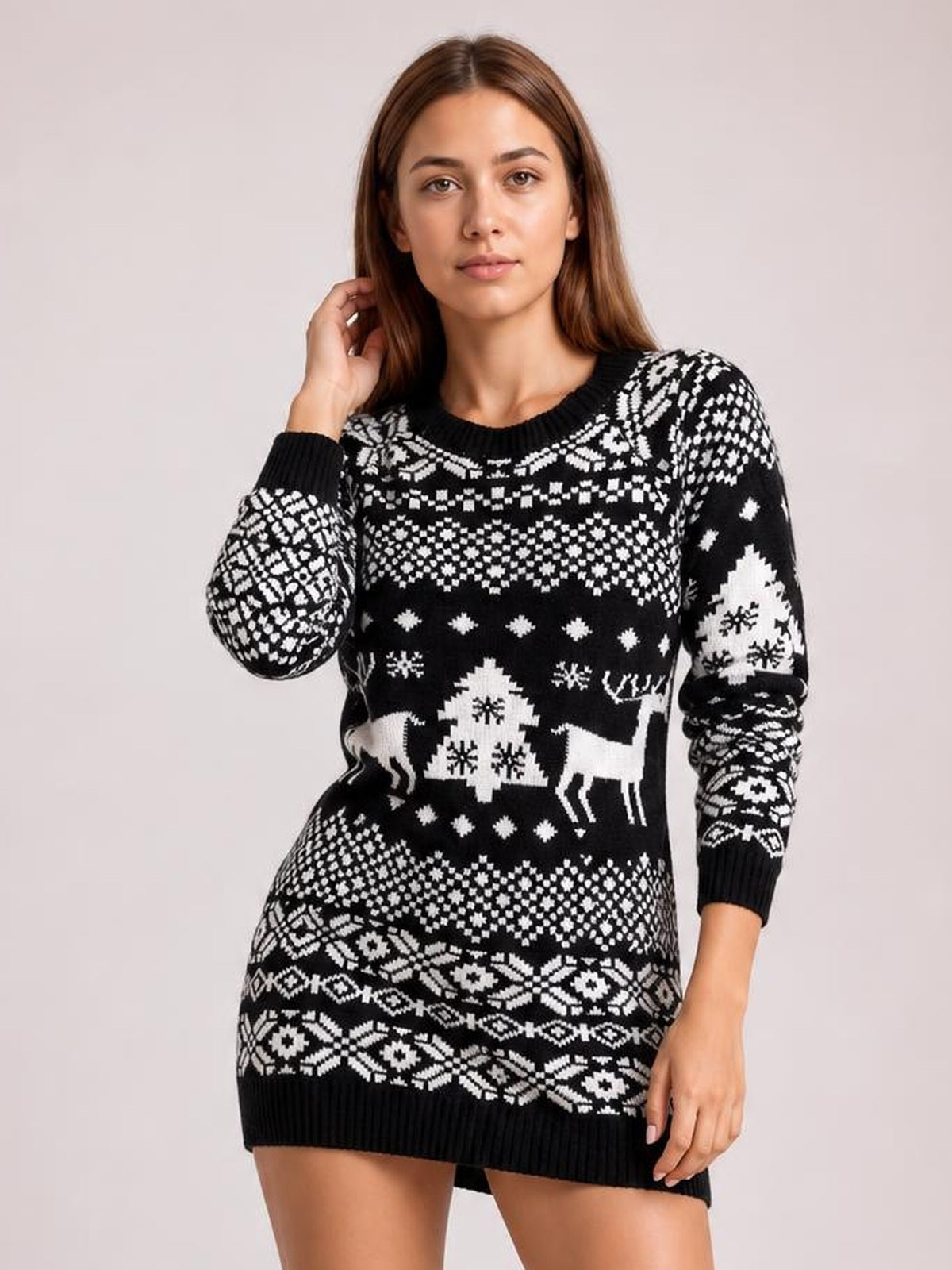 Model poses in a black-and-white Christmas round-neck mini sweater dress with long sleeves, ribbed cuffs and hem, and festive reindeer and snowflake motifs.