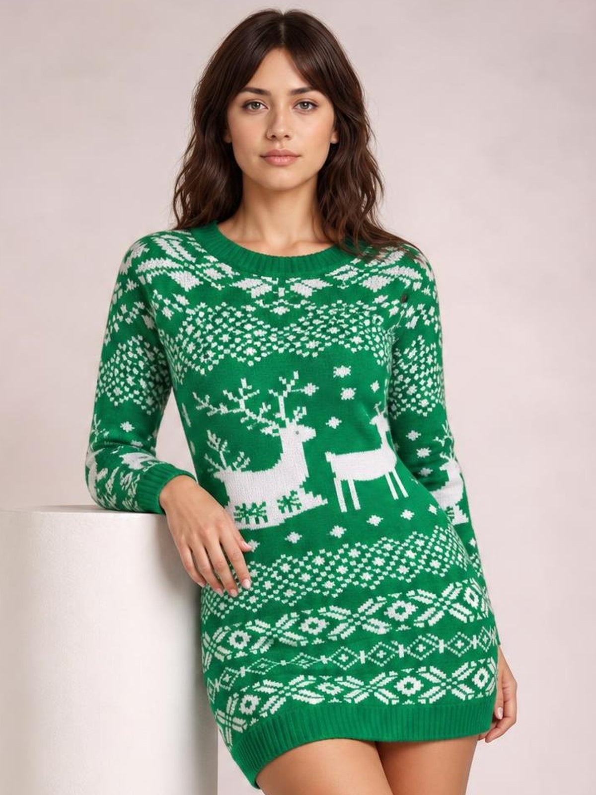 Model wears a green Christmas mini sweater dress with a ribbed round neck, long sleeves, white reindeer and Fair Isle patterns, and a fitted silhouette.