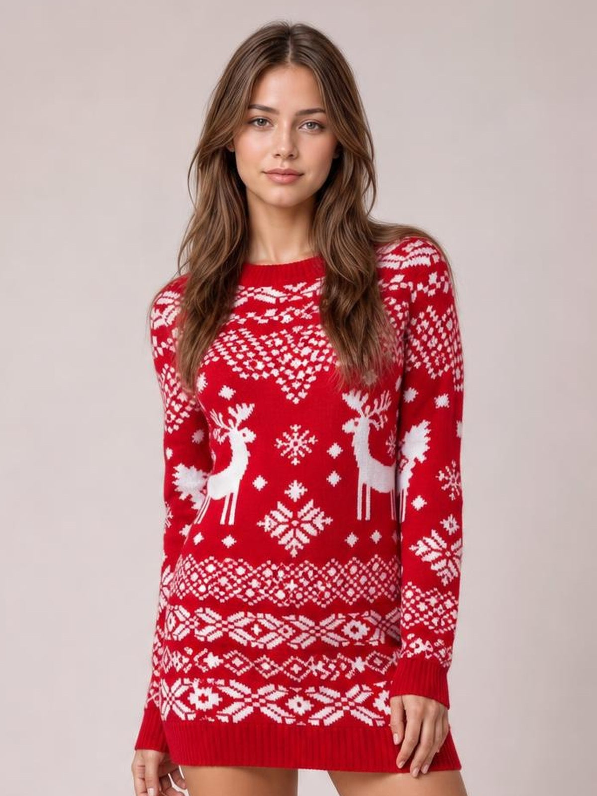 Model wearing a red round-neck mini sweater dress with long sleeves, white reindeer, snowflake, and Fair Isle patterns in a relaxed standing pose.