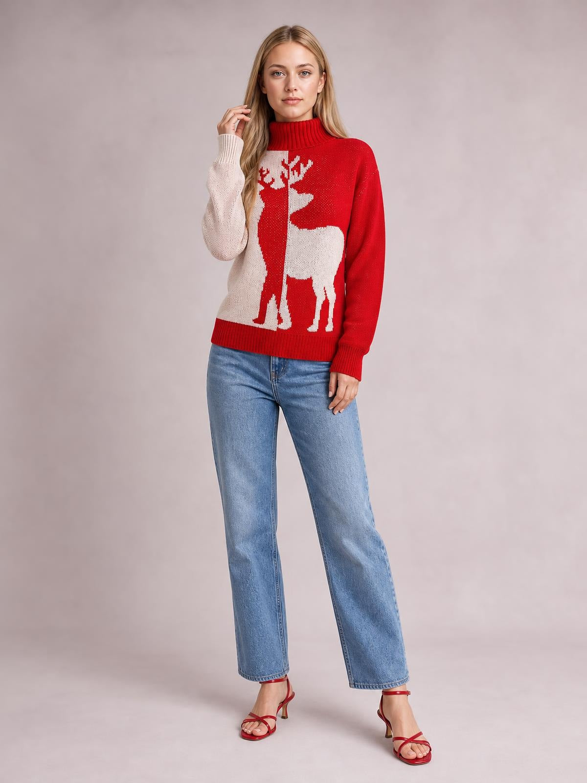 A woman poses in a red ribbed Christmas reindeer turtleneck sweater with long sleeves, a relaxed straight silhouette, and white reindeer motif.