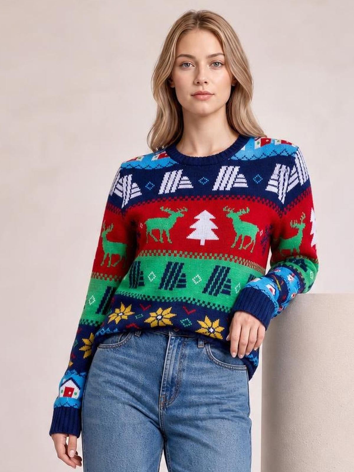 Model poses in a colorful Christmas round neck sweater with long sleeves, ribbed trim, and festive reindeer, tree, and geometric patterns in a relaxed silhouette.