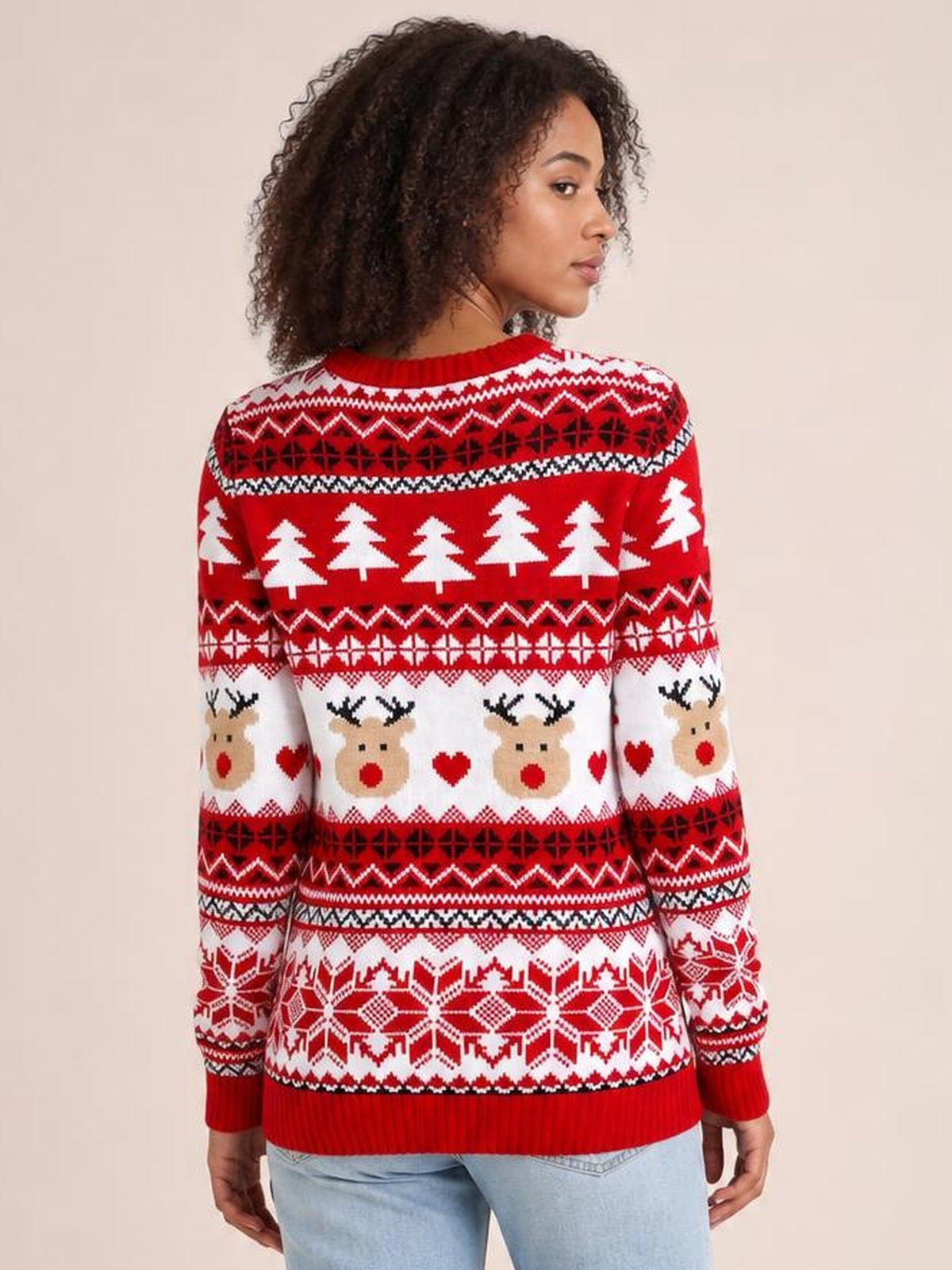 Model shown from the back in a red Christmas round neck sweater with long sleeves, ribbed cuffs and hem, and festive reindeer, tree, and snowflake patterns.