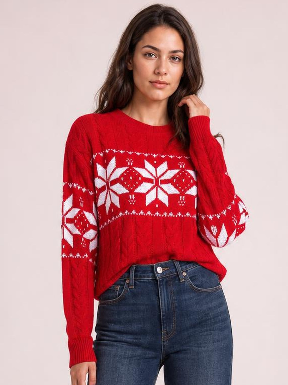 Model poses in a red Christmas snowflake cable-knit sweater with white patterned bands, crew neckline, long sleeves, and a relaxed silhouette.