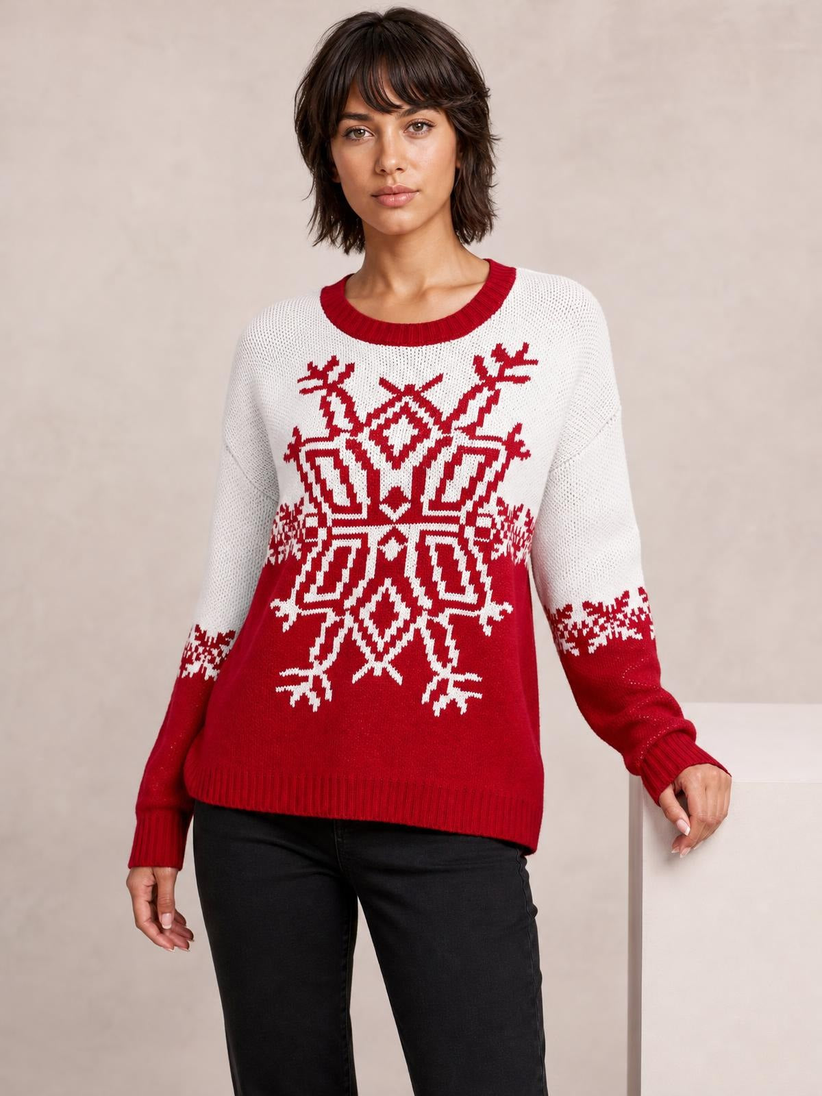 A model wears a red and white Christmas snowflake sweater with a round neck, long sleeves, ribbed cuffs and hem, and a relaxed silhouette.