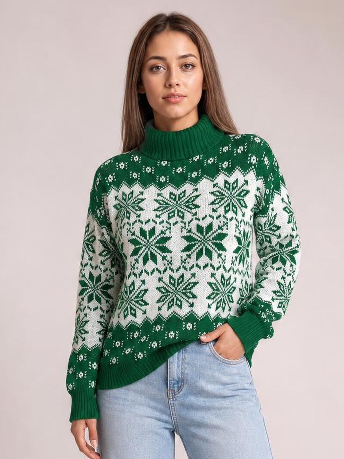 Model wearing a green ribbed turtleneck sweater with white Christmas snowflake patterns, long sleeves, a relaxed silhouette, and one hand in her jeans pocket.
