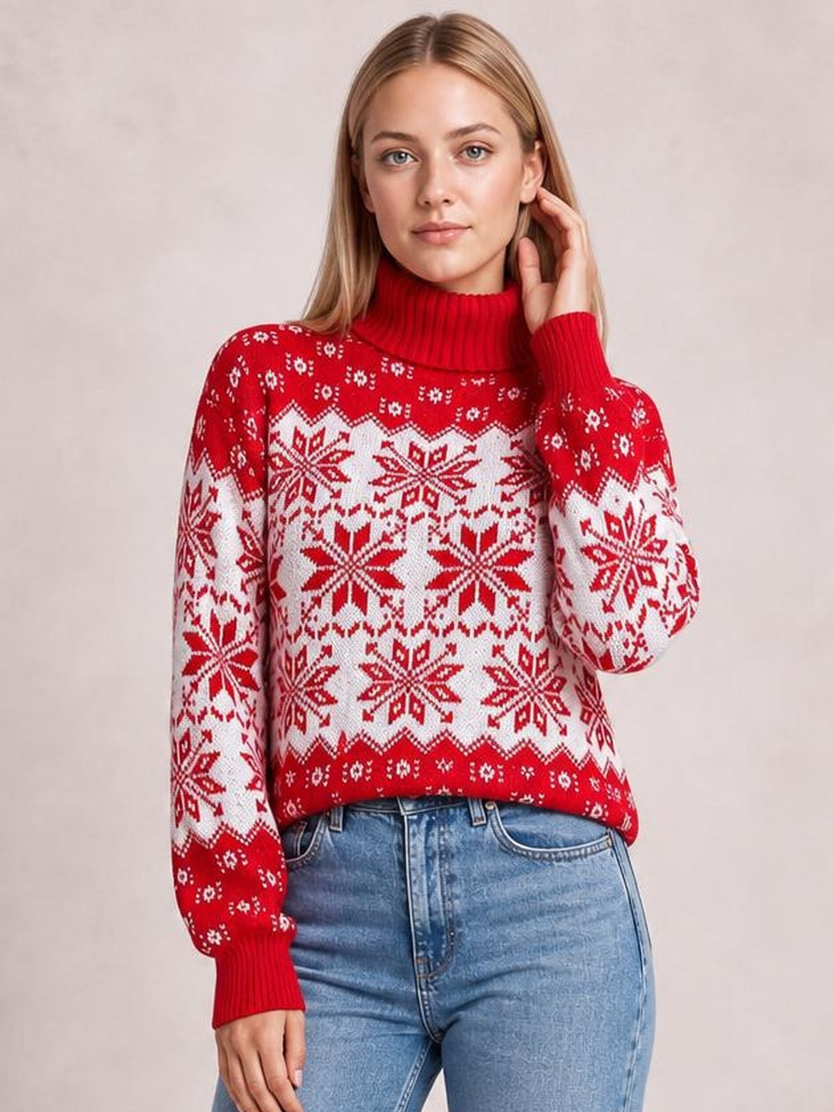 Model poses in a red and white snowflake turtleneck sweater with long sleeves, ribbed cuffs and collar, and a relaxed silhouette.