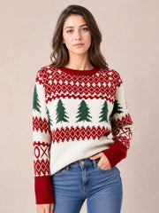 A woman poses in a relaxed cream Christmas tree pattern sweater with red and green Fair Isle detailing, round neck, ribbed cuffs, and a comfortable silhouette.