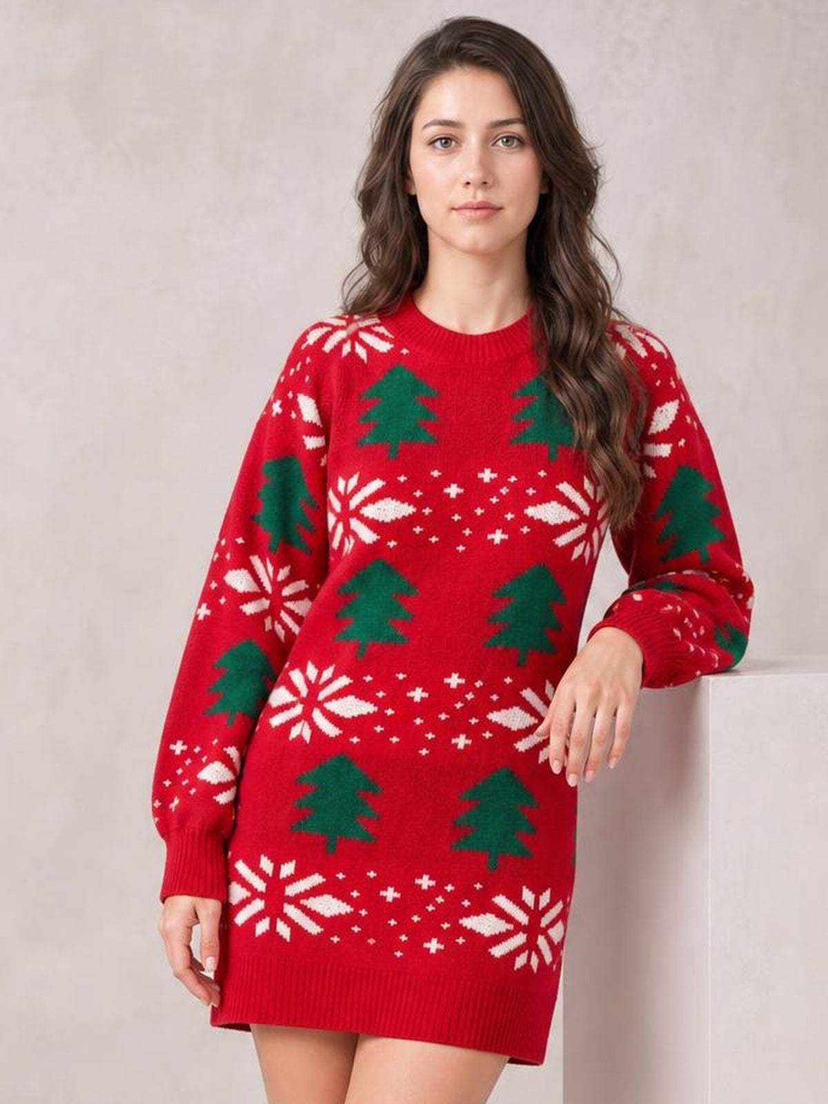 Model wears a red Christmas tree sweater dress with a round neck, long sleeves, ribbed cuffs and hem, and a relaxed above-knee silhouette.