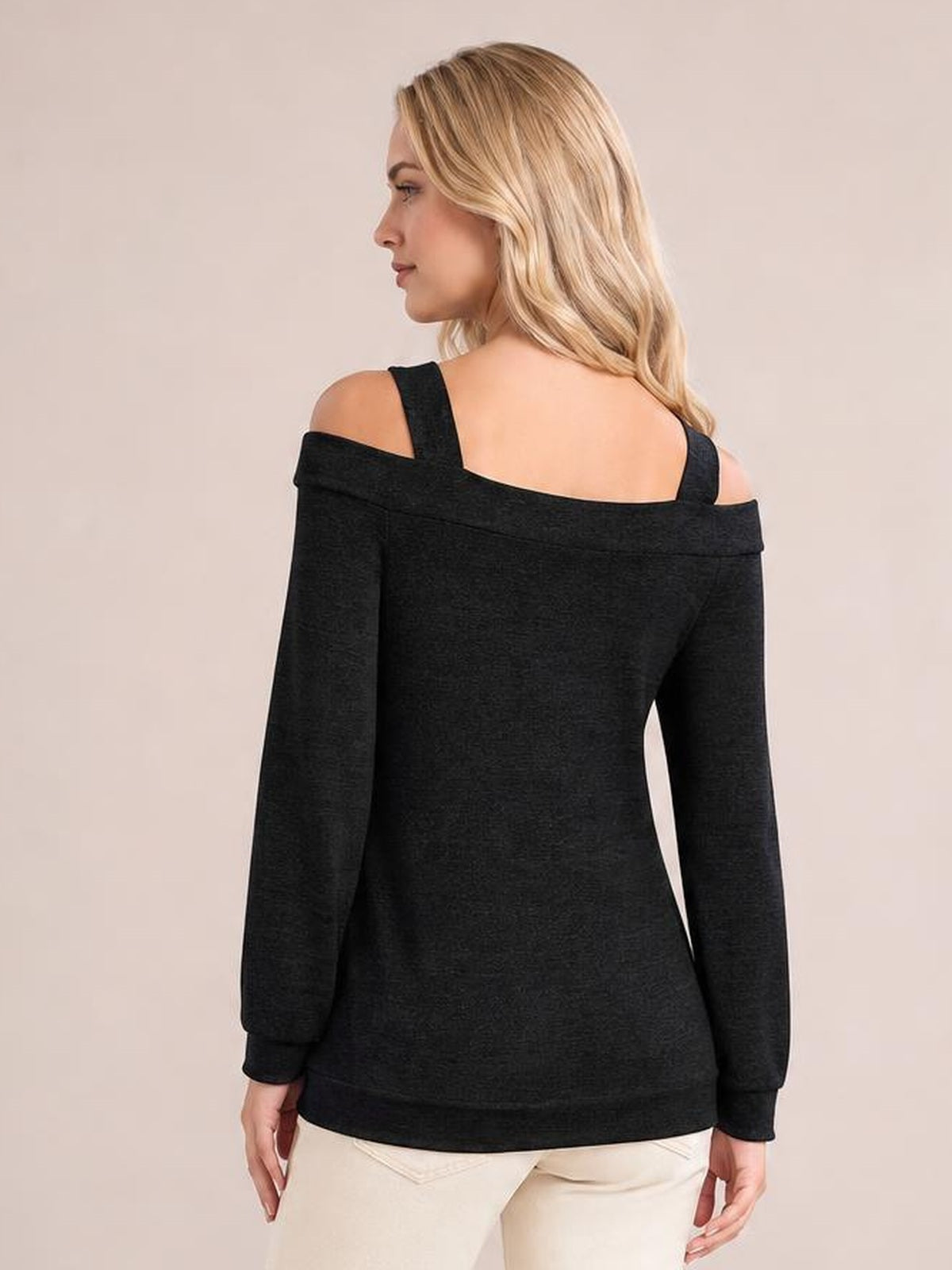 A model shown from behind wears a black cold shoulder blouse with shoulder cutouts, wide straps, long sleeves, and a relaxed straight silhouette.