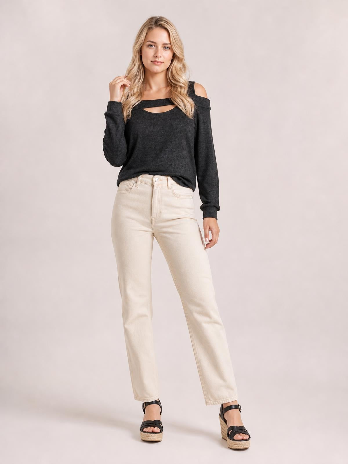 Model poses in a dark gray cold shoulder blouse with a square neckline, shoulder cutouts, long sleeves, and a relaxed silhouette.