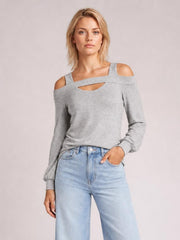 Model poses in a gray cold shoulder blouse with a square neckline, shoulder cutouts, front chest cutout, long sleeves, and a relaxed silhouette.