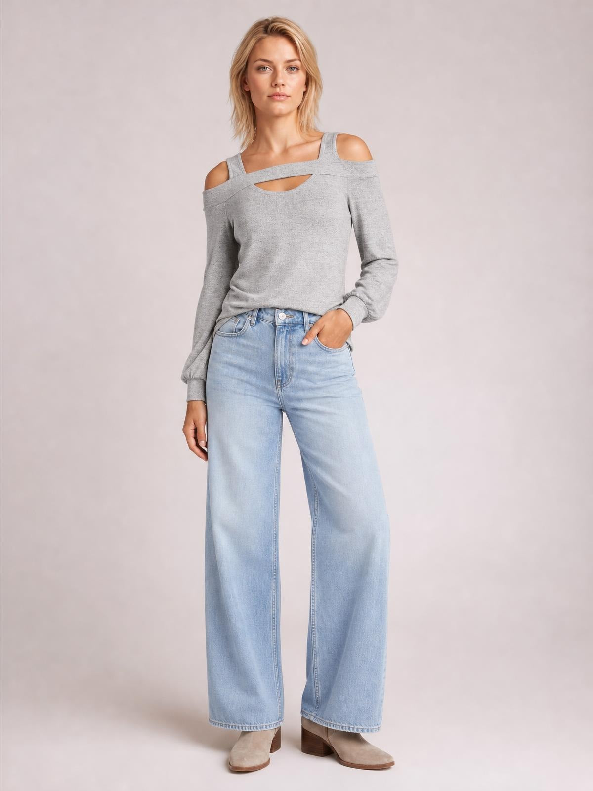 A model poses in a gray cold shoulder blouse with a square neck, layered cutout detail, long sleeves, and a relaxed silhouette.