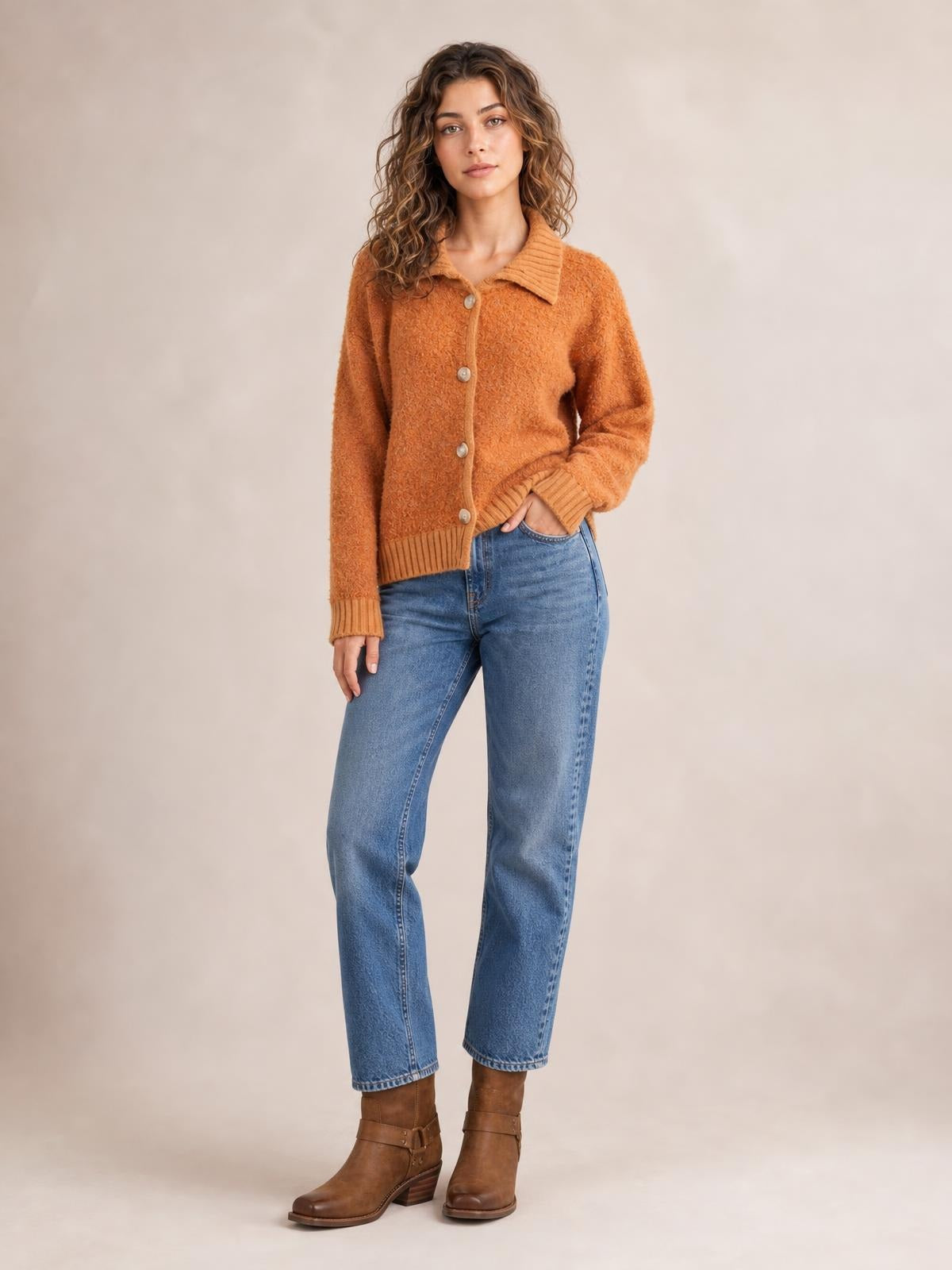 A model poses with one hand in her jeans pocket, wearing a rust-orange collared button-down cardigan with long sleeves, ribbed cuffs and hem, and a relaxed silhouette.