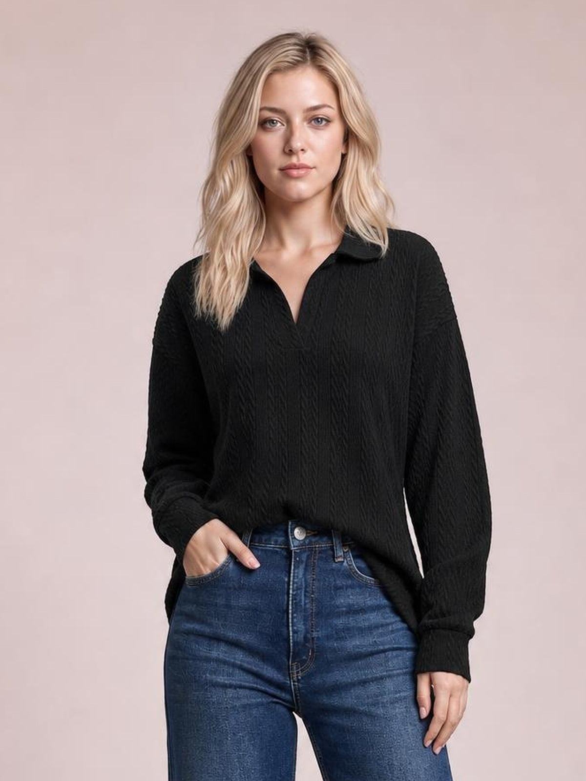 Model in a relaxed pose wears a black cable-knit blouse with a Johnny collar, long regular sleeves, ribbed cuffs, and a loose regular-length silhouette.