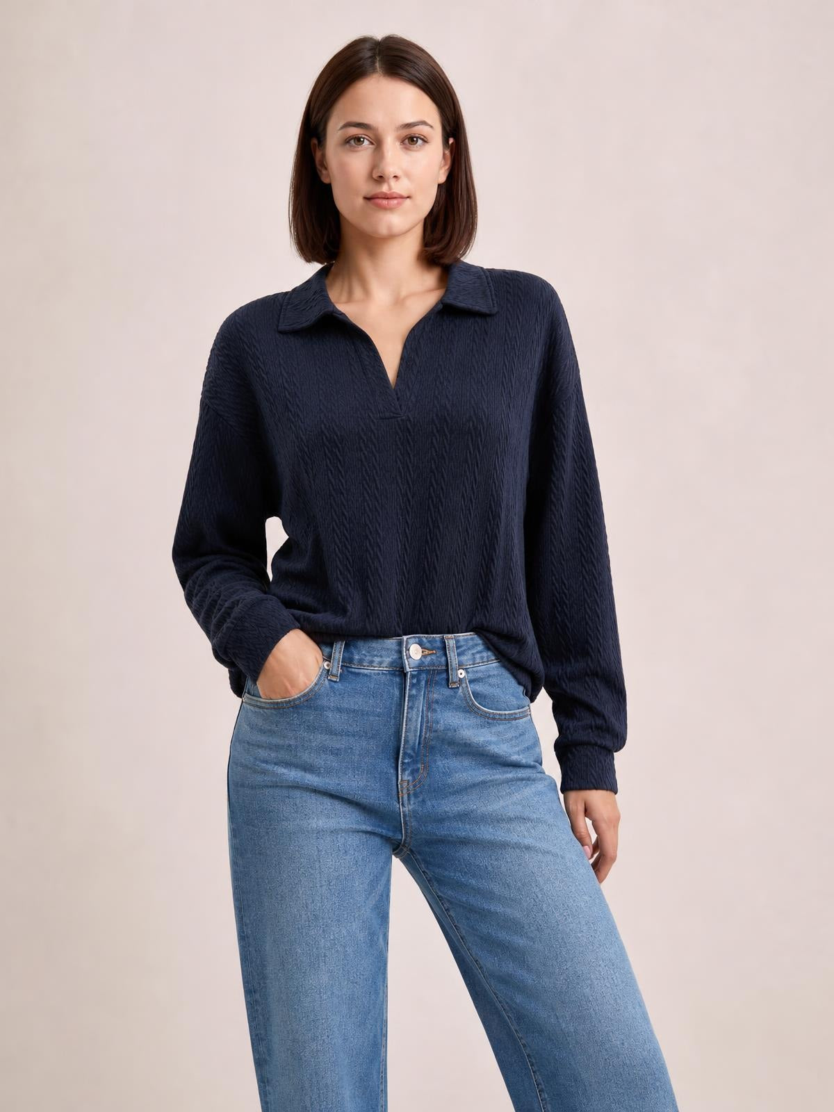 Model wearing a solid navy cable-knit blouse with a collared Johnny neckline, long sleeves, regular silhouette, and slightly relaxed fit.