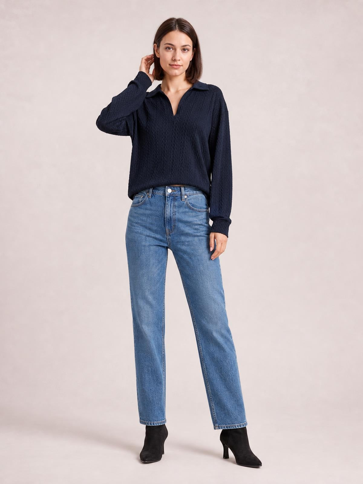 Model wearing a solid navy cable-knit blouse with a Johnny collar, V-neck opening, long sleeves, and a regular-length silhouette.