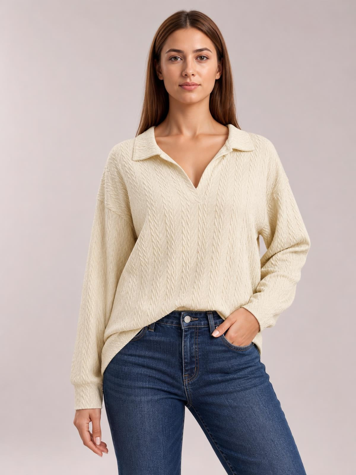 Model wearing an ivory cable-knit blouse with a Johnny collar, V-neck opening, long sleeves, relaxed regular fit, and subtly curved hem.