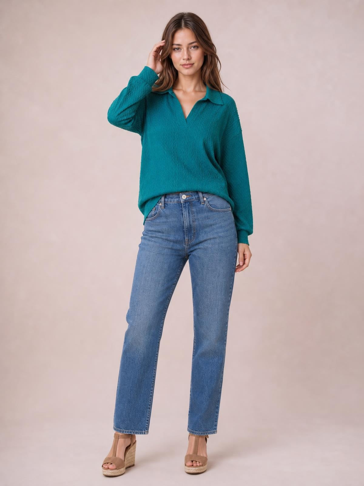 A model poses in a teal cable-knit blouse with a Johnny collar, long regular sleeves, and a relaxed regular-length silhouette, touching her hair.