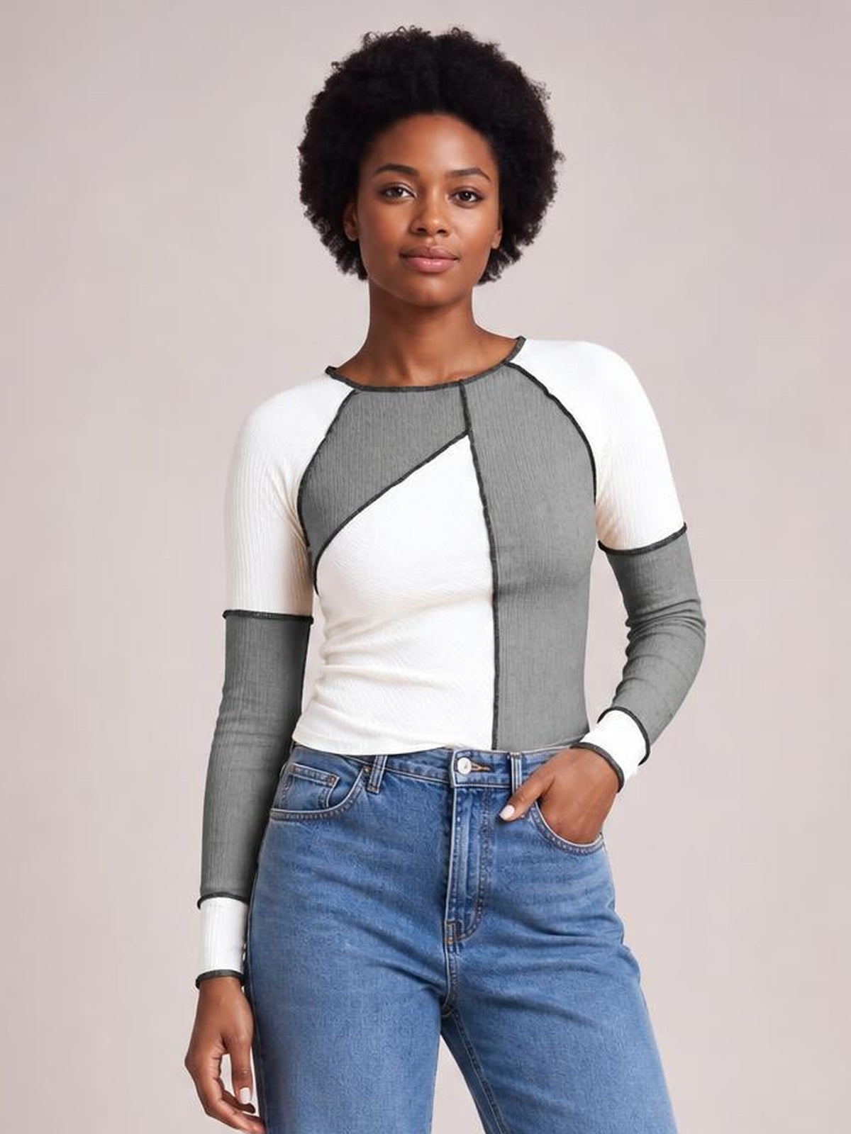 Model wearing a fitted color block ribbed knit top with a round neck, long raglan sleeves, and contrasting exposed seam detailing.