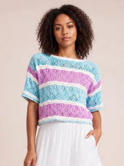 A model poses wearing a lightweight color block openwork sweater with blue, lilac, and white stripes, a relaxed silhouette, and short half sleeves.