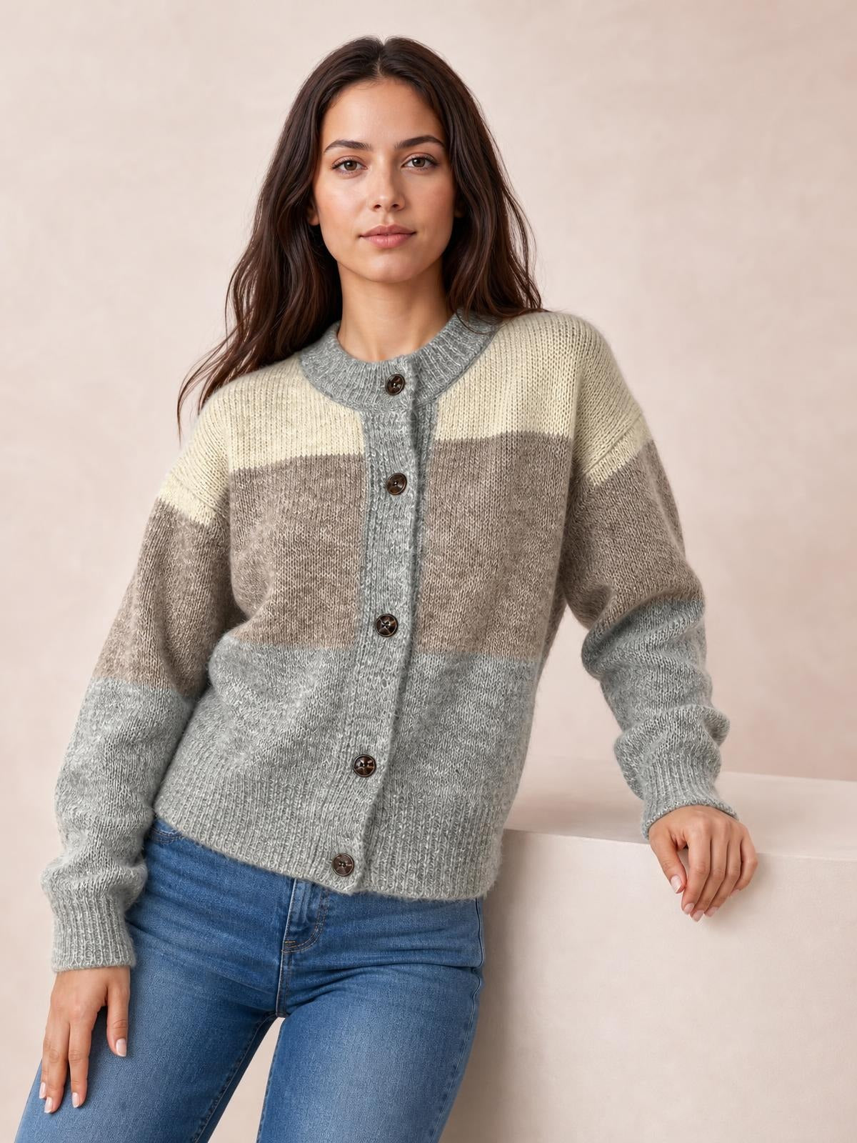 Model wearing a color block round neck button-up cardigan in cream, taupe, and gray with a relaxed silhouette, ribbed trim, long sleeves, and front buttons.
