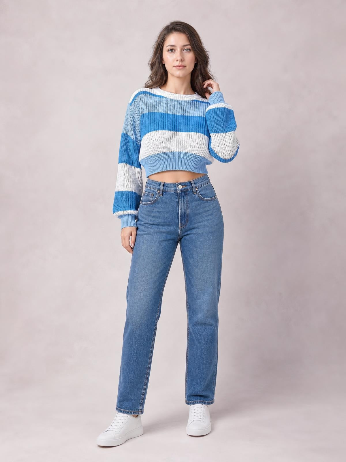 Model poses in a blue-and-white color block cropped sweater with a round neck, long sleeves, ribbed cuffs and hem, and a relaxed silhouette.