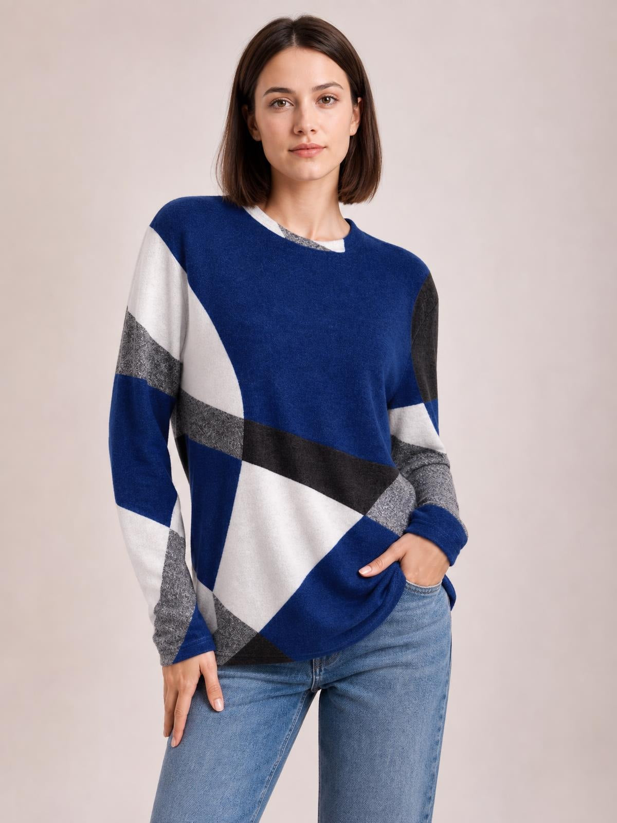 A model wears a blue, white, gray, and black color block T-shirt with a round neck, long sleeves, geometric panels, and a relaxed silhouette.