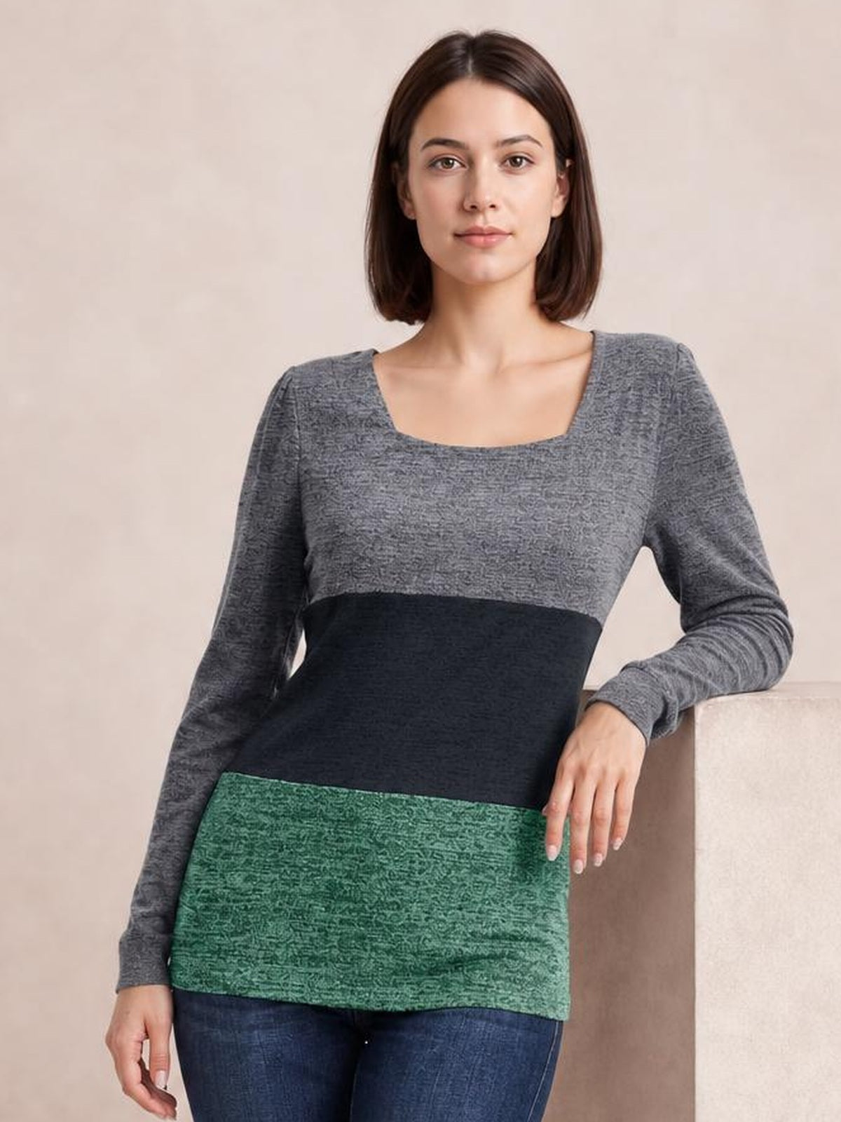 A woman models an opaque color block square neck long sleeve T-shirt with gray, black, and green panels in a straight silhouette.
