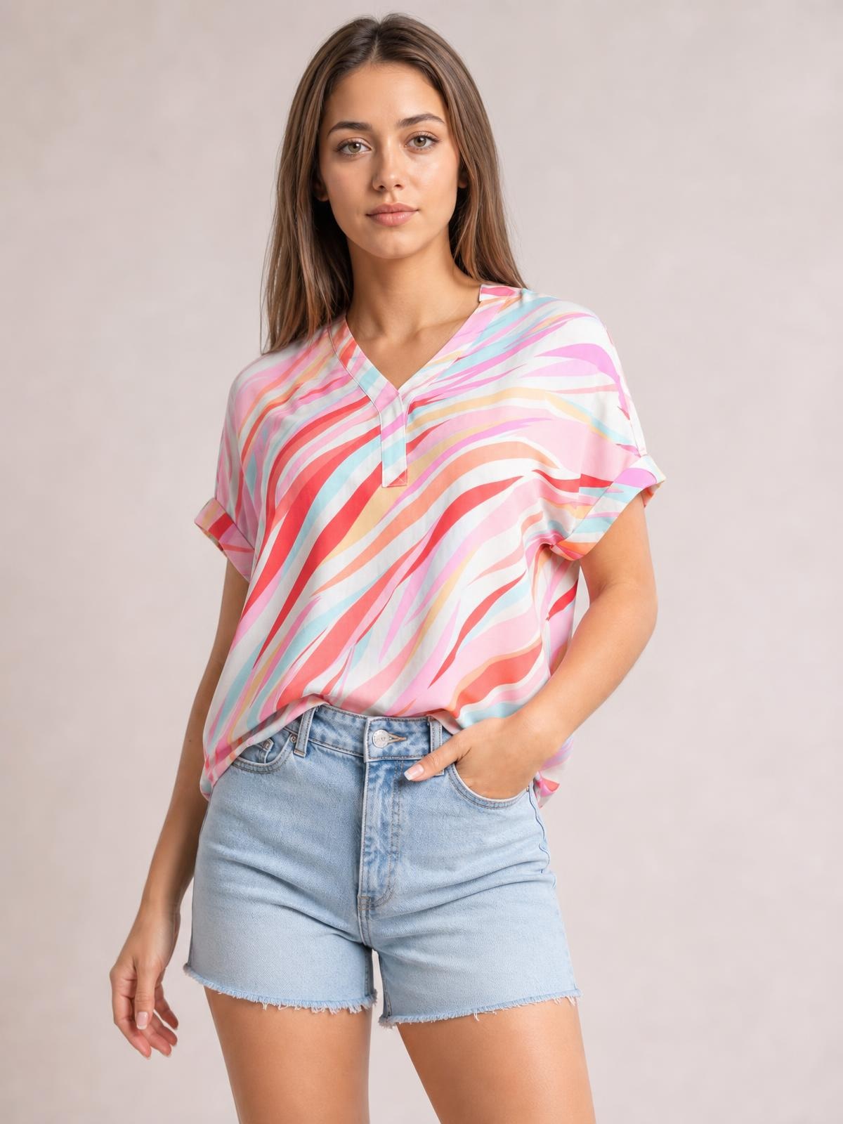 Model wears a loose Color Block V-Neck Half Sleeve Blouse in pastel pink, coral, blue, and yellow stripes, with a V-neck placket and hand in pocket.