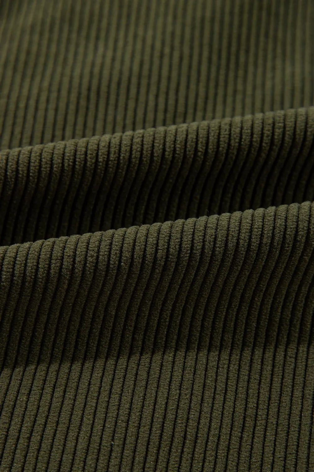 Close-up view of the jacket’s dark olive fabric, showing its dense vertical ribbed texture and layered construction.