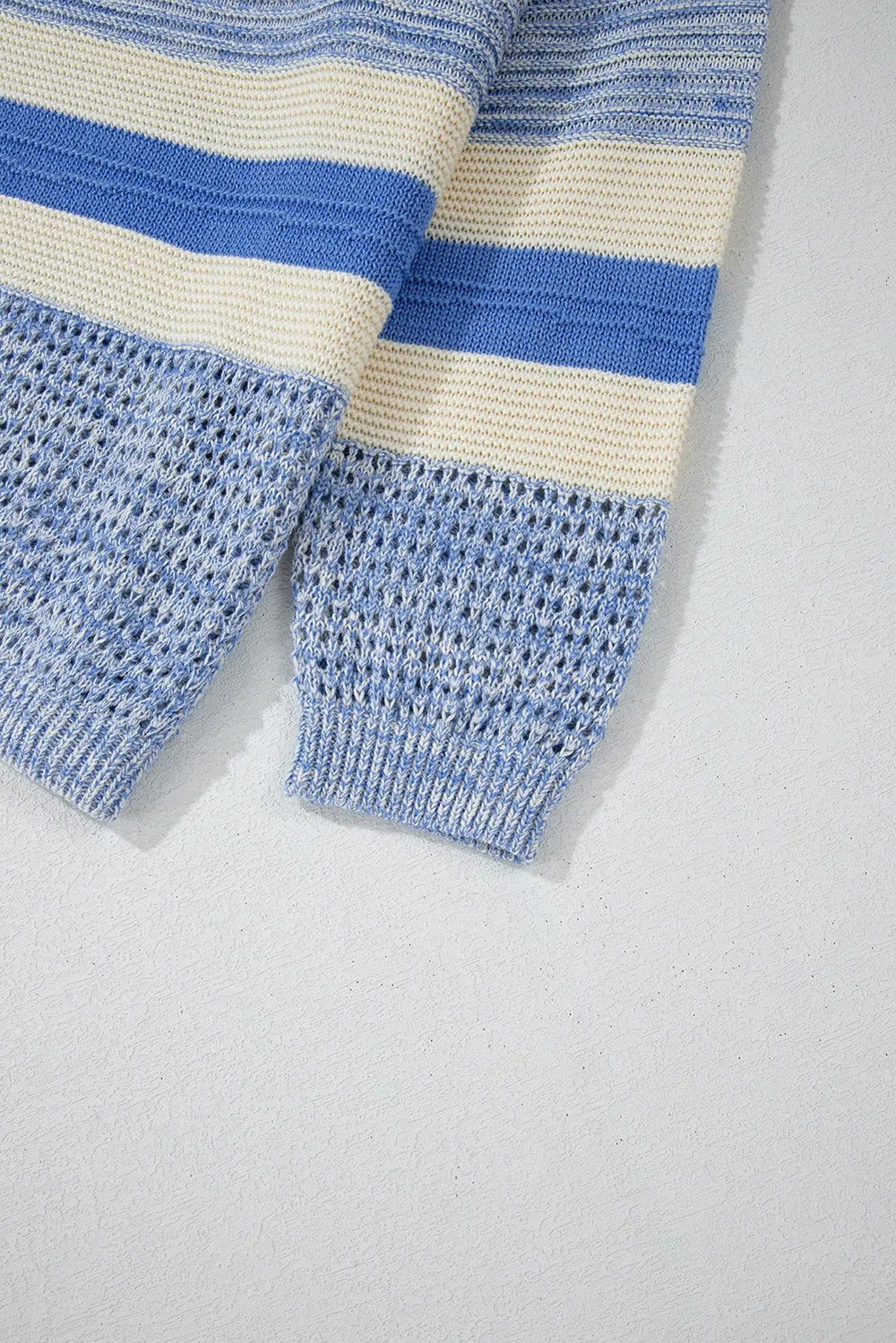 Blue and cream contrast sweater sleeves feature horizontal stripes, textured knit construction, and ribbed cuffs for a softly structured finish.