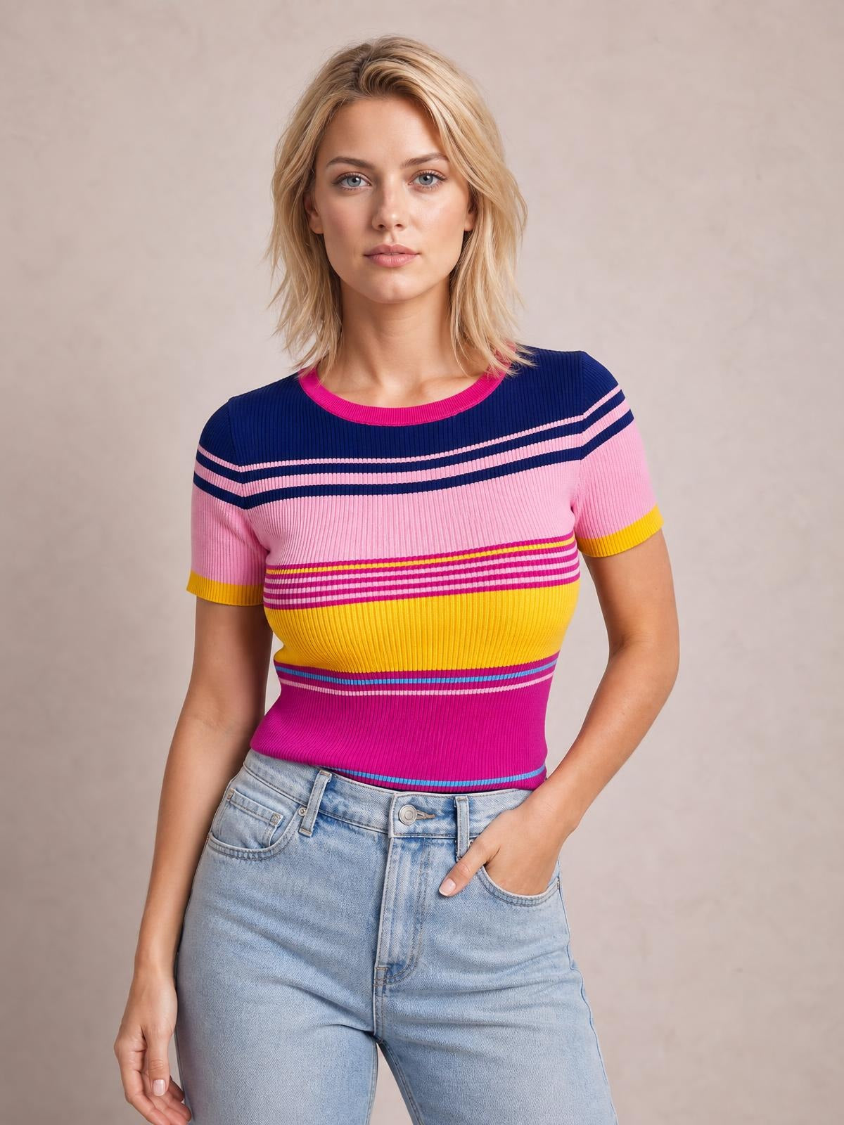 Model in a fitted short-sleeve sweater with a round neckline, colorful pink, navy, yellow, and magenta striped contrast design, and ribbed construction.